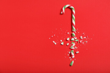 Crushed candy cane on red background, flat lay with space for text. Christmas treat