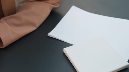 precise edge positioning technique, caucasian artist arranges paper accurately on table, designer meticulously adjusts sheet edges ensuring precise placement and neat layout for composition