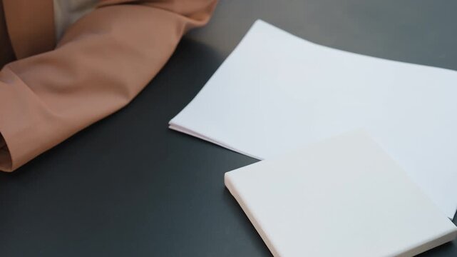 precise edge positioning technique, caucasian artist arranges paper accurately on table, designer meticulously adjusts sheet edges ensuring precise placement and neat layout for composition