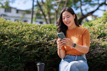 Asian girl smiling connecting cellphone outdoors
