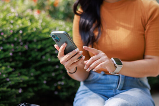 Woman using smartphone outdoors scrolling social media app