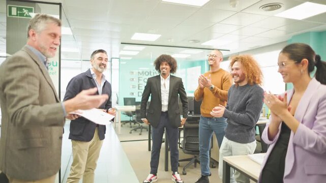 Team clapping for a successful presentation in a contemporary office.