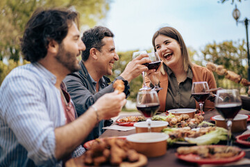Friends enjoying outdoor dinner and toasting together at a relaxed backyard gathering