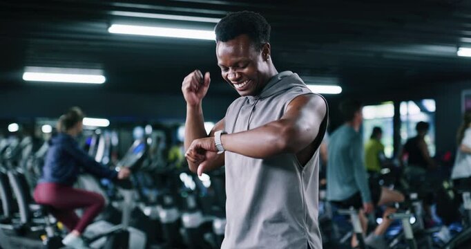 Smart watch, fitness or man in gym, fist pump or workout with digital app to track progress. Athlete, celebration or person in health center, wellness or achievement with training and exercise goals