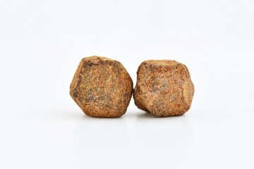 Two raw fragments of Spessartine Garnet (manganese aluminum silicate) crystals, showcasing their characteristic reddish-brown color and rough, granular texture on a white background.
