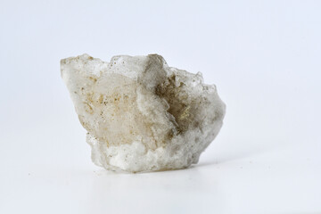 A chunk of raw, white Halite (rock salt) mineral, showing its cubic crystalline structure and translucent nature, isolated on a white background for educational or stock use.