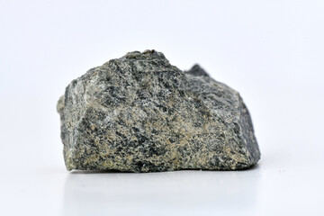 A raw, dark green specimen of Diopside, a pyroxene mineral, showcasing its natural crystalline structure and rough surface texture against a clean white background.