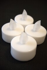 4 white electric candles on a black background with Copy Space in natural condition.