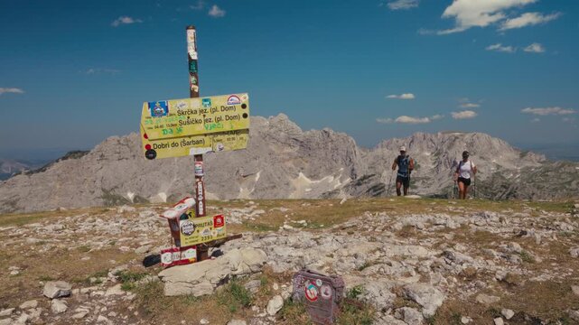 Hikers nearing signpost on sunny Prutas Hike Loop, Durmitor National Park