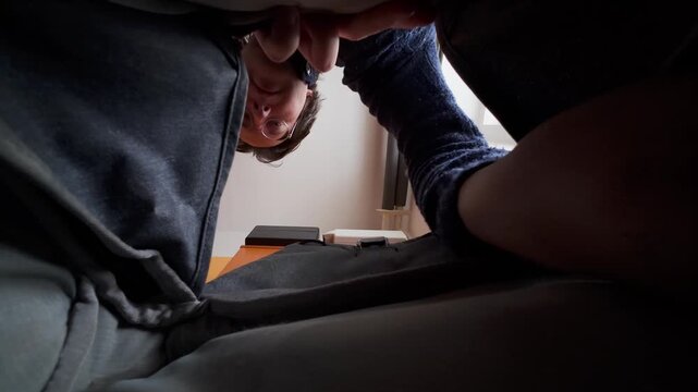 The man opens his backpack and searches for the white headphone case, which he then takes out.