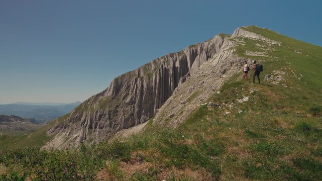 Hikers explore rugged mountain path in Durmitor's stunning landscapes