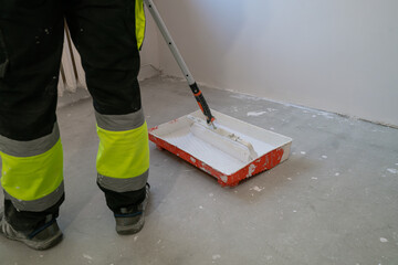 Paint tray with paint and a paint roller.