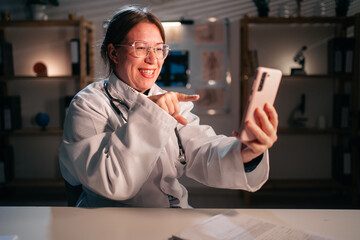 happy woman doctor laughing at comedy or chat on social media relax on workplace working during night shift in hospital