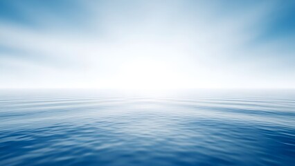 Calm blue ocean with bright sky and soft clouds background
