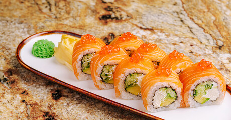 Sushi rolls served on a plate with wasabi and pickled ginger