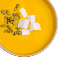 Delicious pumpkin soup topped with cheese and seeds served in a bowl