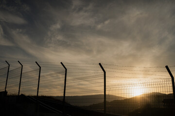 Border Fence at Sunset. Migration and Political Tension Concept