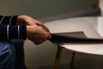 Close-up photograph of human hands flipping through a magazine. Clear details of the paper, texture, and page movement. Perfect for lifestyle imagery, education, reading habits, print media