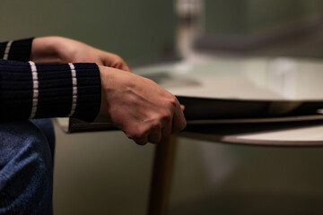 Naklejka premium Close-up photograph of human hands flipping through a magazine. Clear details of the paper, texture, and page movement. Perfect for lifestyle imagery, education, reading habits, print media