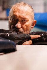 Portrait of senior free diver in wetsuit looking at camera at poolside 