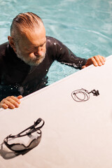 High angle view of diver resting near goggles and nose clip on poolside 
