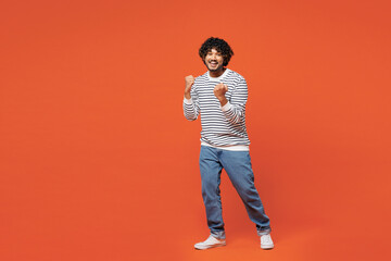 Full body young smiling happy Indian man wear striped sweatshirt casual clothes doing winner...