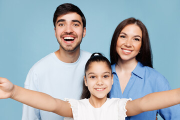Obraz premium Close up young happy parents mom dad with child kid daughter girl wear casual clothes doing selfie shot on mobile cell phone isolated on plain blue background. Family day parenthood childhood concept.