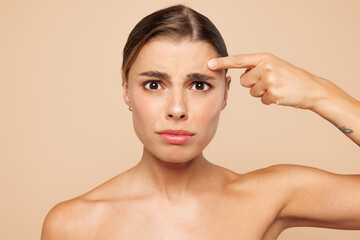 Close up beautiful half naked topless young woman 20s with nude make up point index finger on...