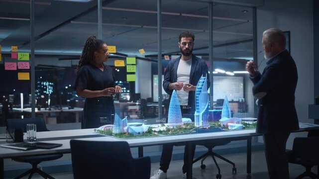 Architects Collaborate Late in a Glass Office, Reviewing a Holographic Smart City Model, Futuristic Skyline Concepts, Sustainable Master Planning, and High Tech Urban Development Strategy Together.