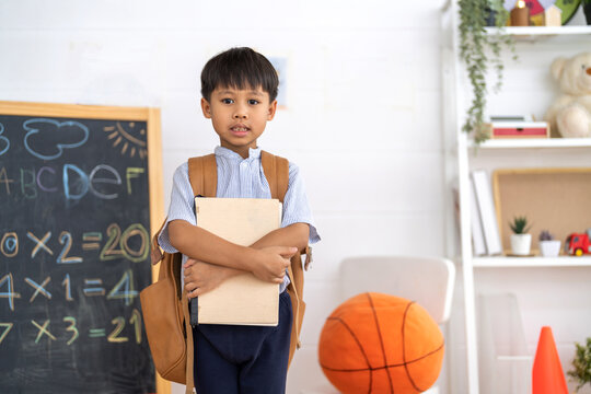 Asian schoolboy wearing uniform with backpack ready to learn at home, representing education, first day of school, childhood learning and academic preparation, education, back to school concept - Powered by Adobe
