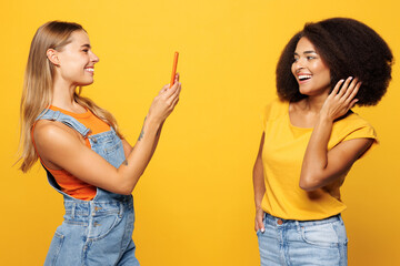 Side view two young friends buddies women wear casual clothes together taking photo shot on mobile...