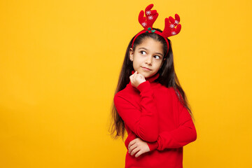 Merry little girl wear red clothes fun decorative deer horns on head posing show thumb up like...