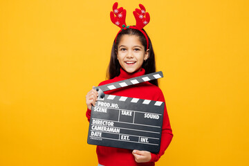 Merry little girl wear red clothes fun decorative deer horns on head posing hold classic black film...