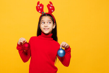 Merry little girl wearing red clothes fun decorative deer horns on head posing hold in hand...