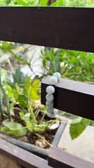 Elegant Beaded Stone Bracelet Hanging on Outdoor Wooden Railing