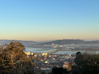 Fototapeta premium Cityscape with Lima river and Ponte Eiffel Bridge at sunset, Viana do Castelo, Portugal, January 2024