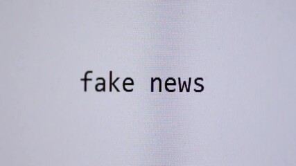 Words “fake news” being typed on a blank digital screen, representing misinformation, online deception, media distortion, and modern information risks in the digital age