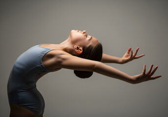 Young ballerina gracefully arches back in a studio setting