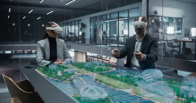 Architect and Engineer Wearing Vr Headsets Collaboratively Shape a Futuristic Coastal Eco-city, Manipulating Holographic Skyscrapers, Transport Networks, and Green Spaces on a Smart Table