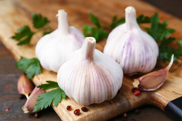 Fresh garlic, peppercorns and parsley on wooden table, closeup