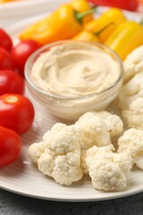 Different fresh vegetables and sauce on table, closeup