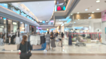 Eye-level shot, intentionally blurred (bokeh) photo of a bright outdoor shopping plaza or courtyard with people walking, providing a soft, abstract background texture for design overlay