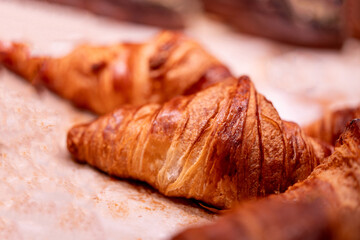 Delicious croissants warming on parchment paper, offering a tempting treat for breakfast or dessert