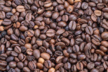 Roasted beans showcase textures, Detailed image capturing glossy roasted coffee beans with irregular shapes and subtle highlights highlighting aroma and craft aesthetic