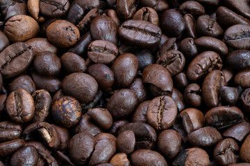 Macro study of roasted coffee beans highlighting cracked surfaces and grainy texture, highcontrast lighting emphasizes tactile detail for product photography and texture backdrops