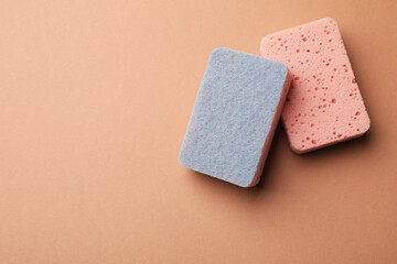 Kitchen sponges on brown background, top view. Space for text