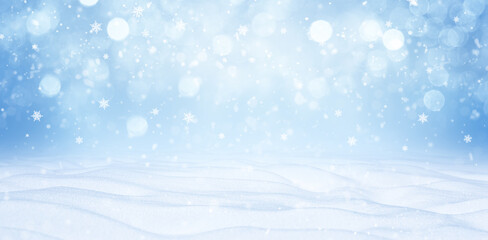 A winter Christmas snow background with snowdrifts and beautiful bokeh lights with snowflakes and garlands. Banner format, copy space.