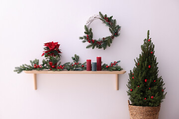 Stylish room with small spruce tree and Christmas decor. Interior design