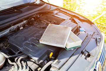 New clean and old dirty air filter in the engine compartment of the car. Technical maintenance of the car, close-up
