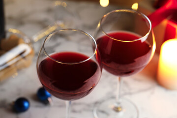 Glasses of red wine and Christmas decor on table, closeup